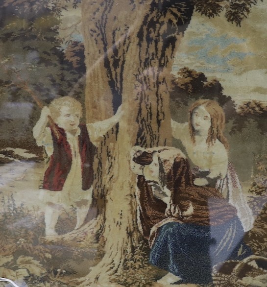 A framed Victorian woolwork panel depicting figures around a tree - 46 x 40cm